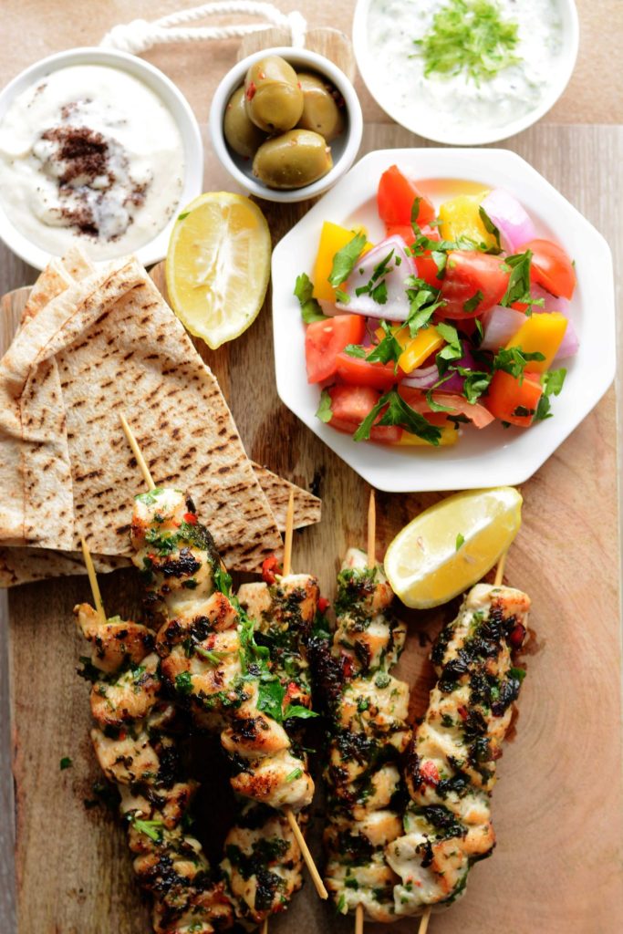 Grilled chicken skewers, pita bread, olives, fresh salad, yoghurt dip