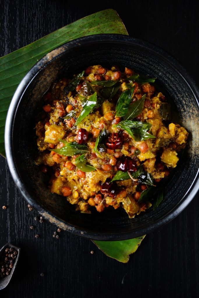 Chickpea and plantain curry served in black bowl