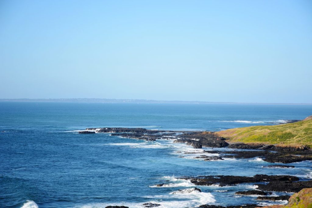 Blue sea, rocky patches and green grass