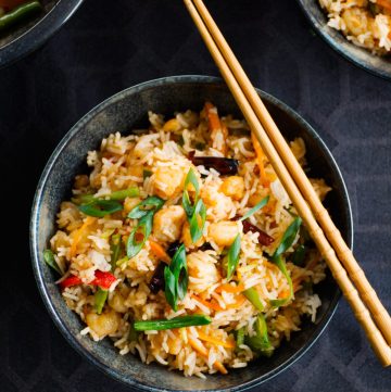 Prawn fried rice served in black bowl with a pair of chopsticks on top