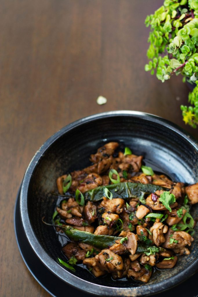 Stir fried chicken served in black bowl