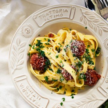 Fettuccine carbonara with sausage meatballs served in white plate