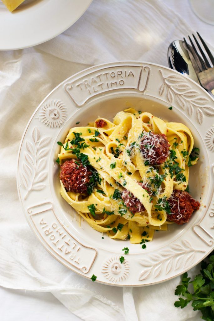 Fettuccine carbonara with sausage meatballs served in white plate