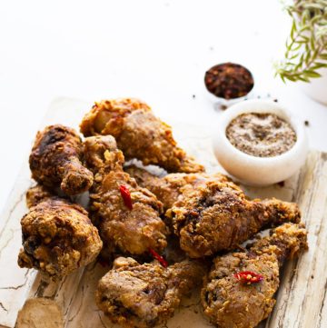 Fried chicken drumsticks served on wooden platter