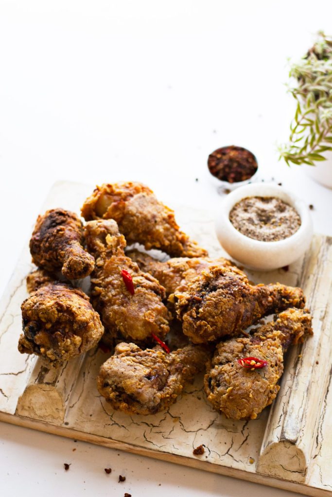 Fried chicken drumsticks served on wooden platter