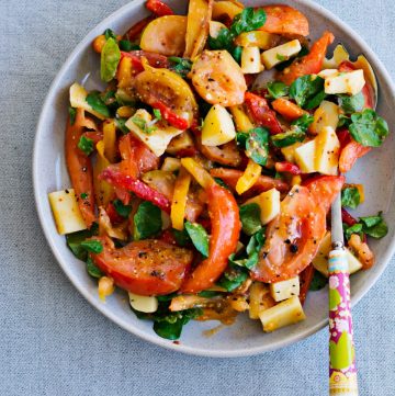 Roasted capsicum, tomato, cheese salad served on grey plate