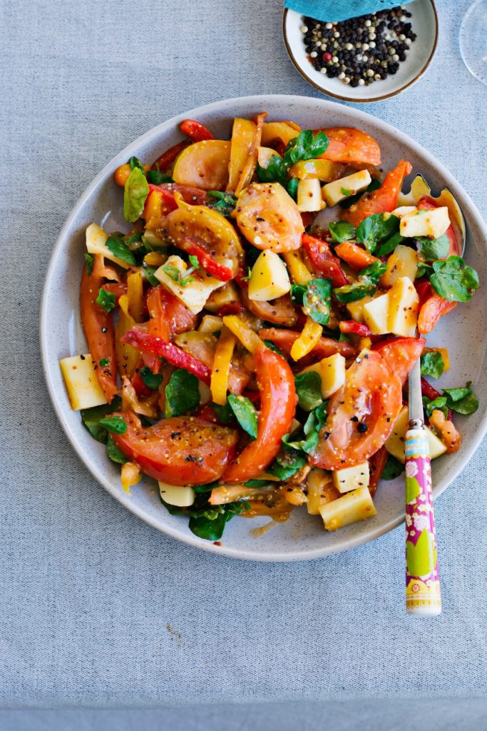 Roasted capsicum, tomato, cheese salad served on grey plate