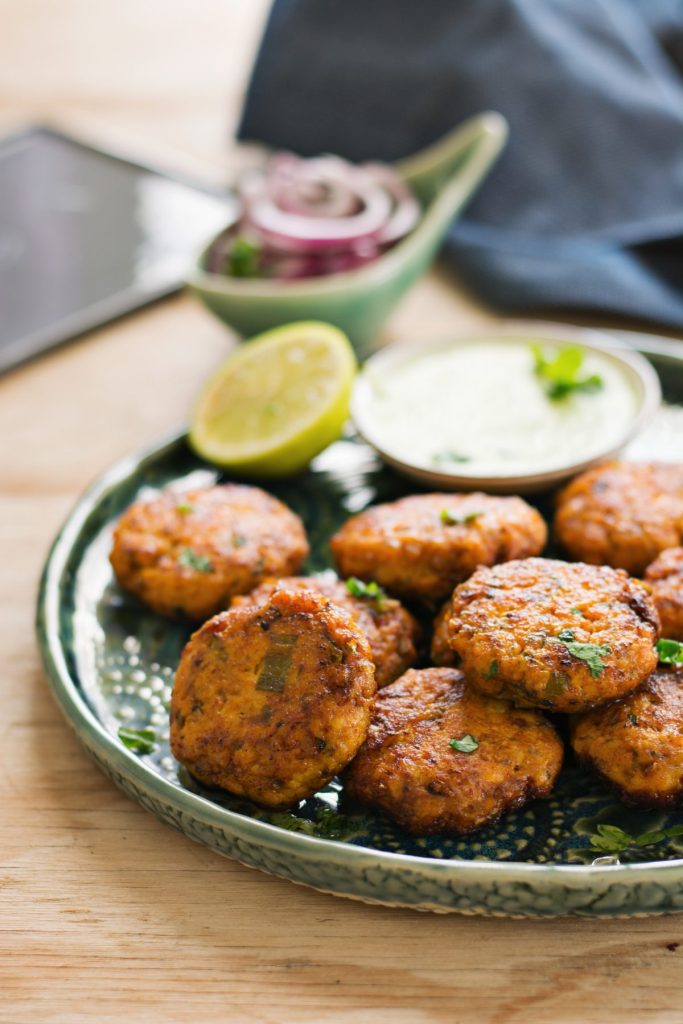 salmon kebabs served in green plate with lime slice on the side