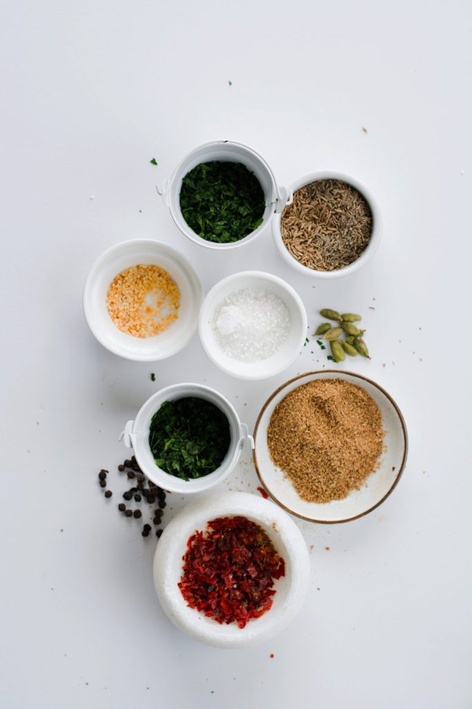 an assortment of spices in separate white bowls