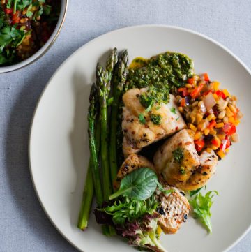 Snapper, green salsa, caponata, asparagus on white plate