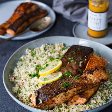 Crispy skin salmon on a bed of cauliflower rice in blue platter