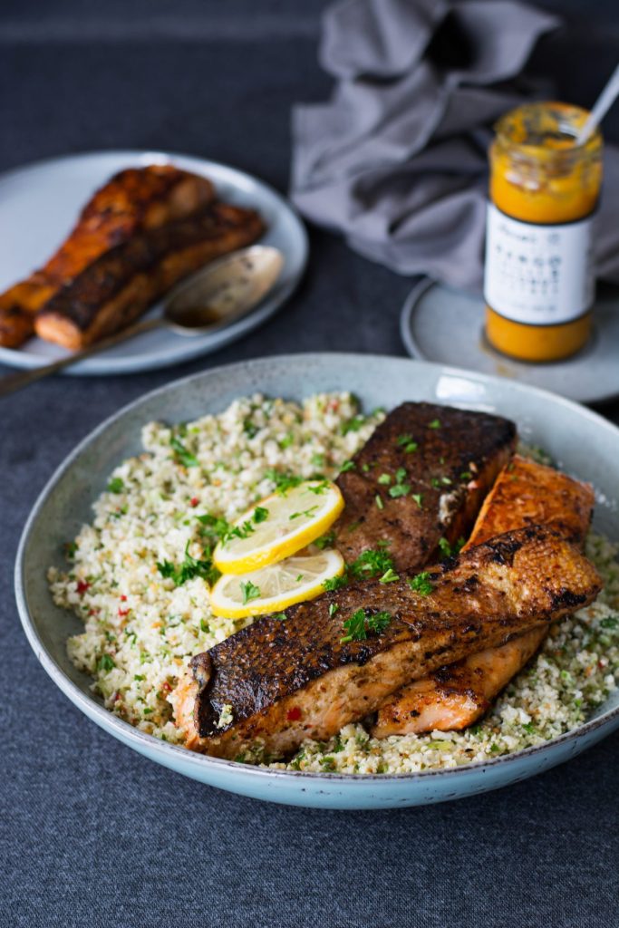 Crispy skin salmon on a bed of cauliflower rice in blue platter