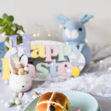 Hot cross bun on a blue egg shaped plate