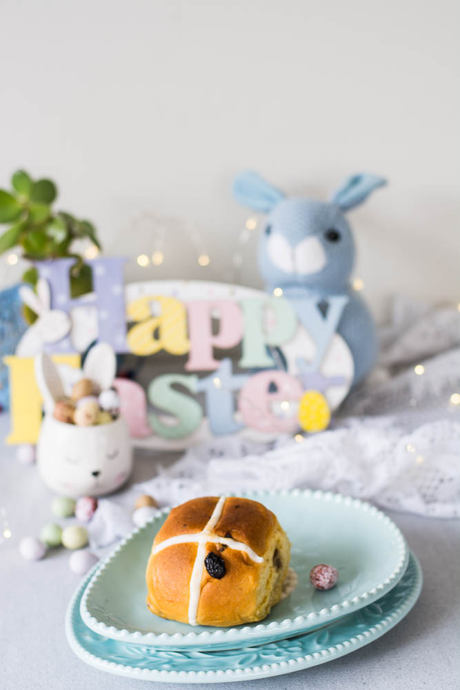 Hot cross bun on a blue egg shaped plate