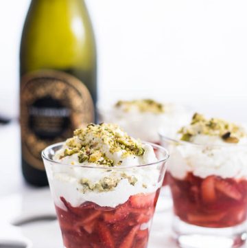 strawberries, cream and sparkling wine dessert in small glass along with a wine bottle