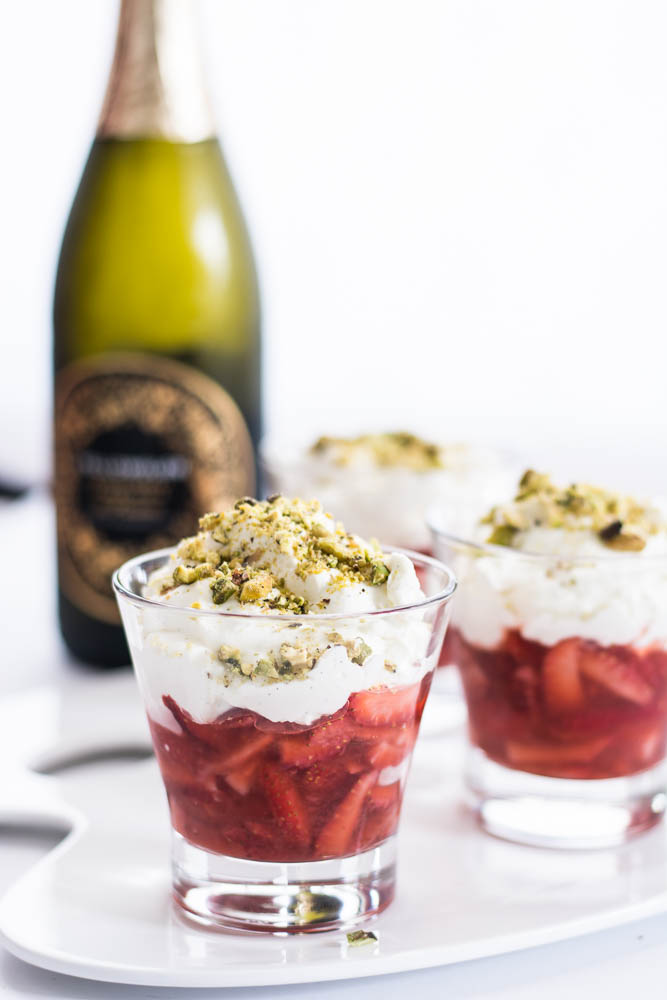 strawberries, cream and sparkling wine dessert in small glass along with a wine bottle