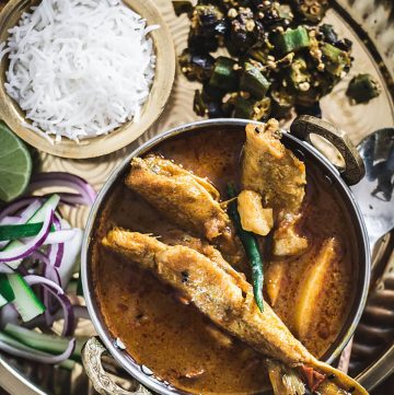 Indian fish curry along with rice and veggies served on platter