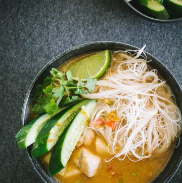 Indonesian style fish stew with noodles in black bowl