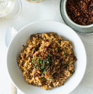 Mushroom risotto in bowl with olives on the side