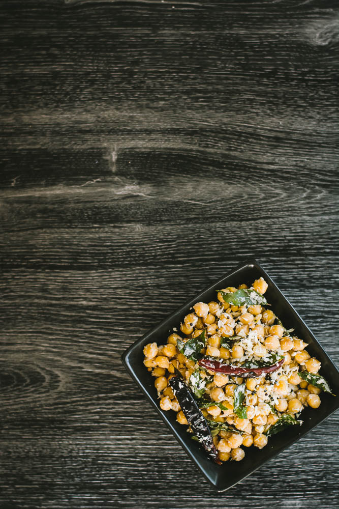 Chickpeas with spices and grated coconut in black bowl