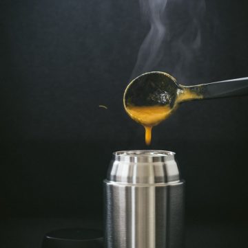 Pouring steaming hot carrot soup into thermos