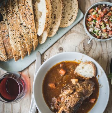 Slow cooked lamb shanks with curry powder and sliced bread on the side