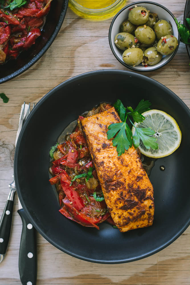 Pan fried salmon with peperonata in black bowl