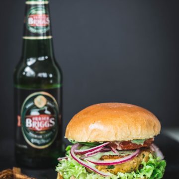 Tandoori chicken burger with beer bottle on the side