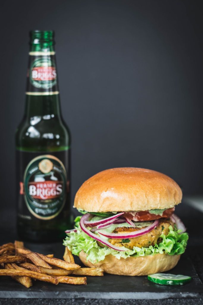 Tandoori chicken burger with beer bottle on the side