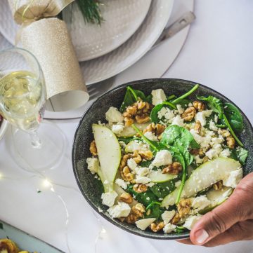 Rocket, spinach, pear salad in blue bowl