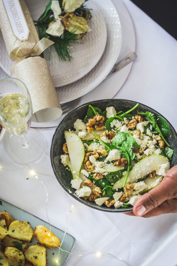 Rocket, spinach, pear salad in blue bowl