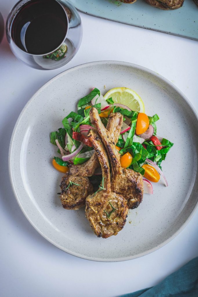 Roasted lamb chops with salad on grey plate