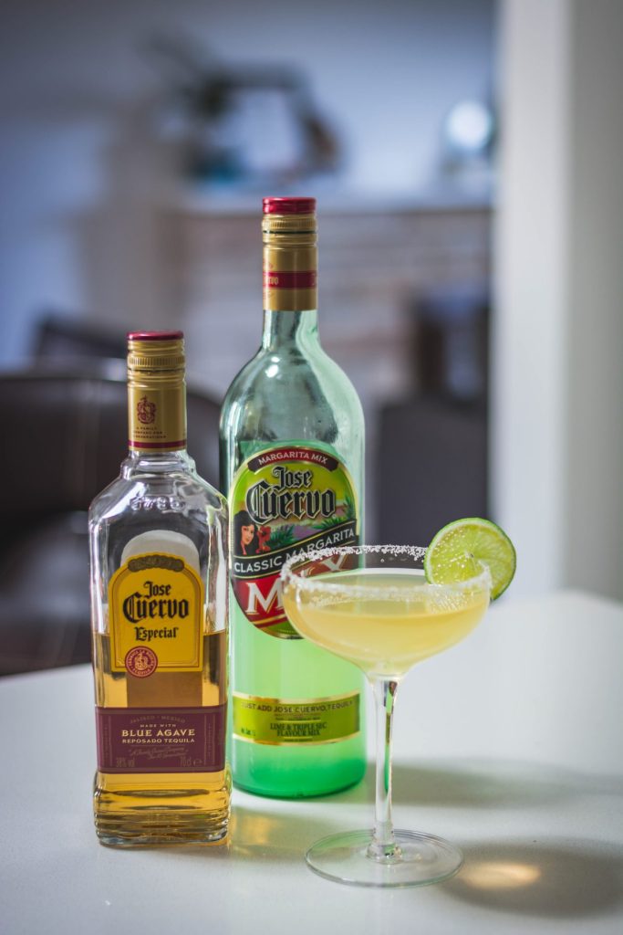 margarita in cocktail glass with tequila bottle on the side
