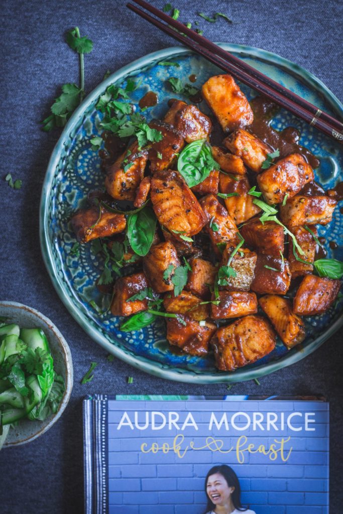 tamarind crispy skin salmon on blue plate with cookbook on the side