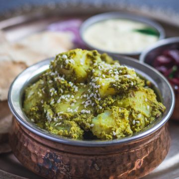 Potatoes in mint coriander masala served in copper bowl