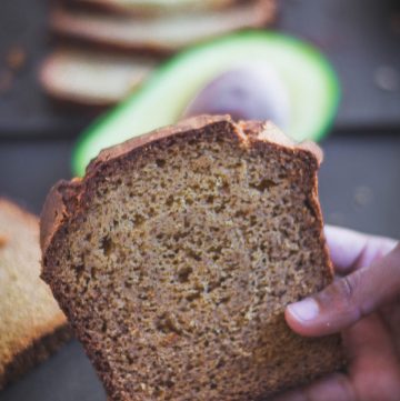 close up of hand holding a slice of avocado banana bread