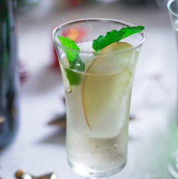 Elderflower Champagne cocktail with pear slice and mint garnish in glass