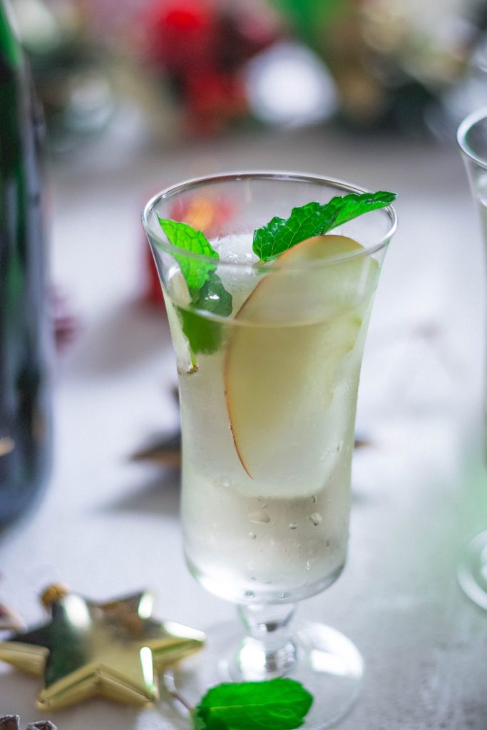 Elderflower Champagne cocktail with pear slice and mint garnish in glass