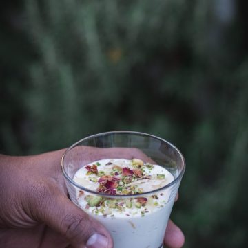 Hand holding glass with Saffron infused yoghurt dessert