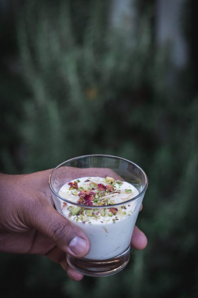 Hand holding glass with Saffron infused yoghurt dessert