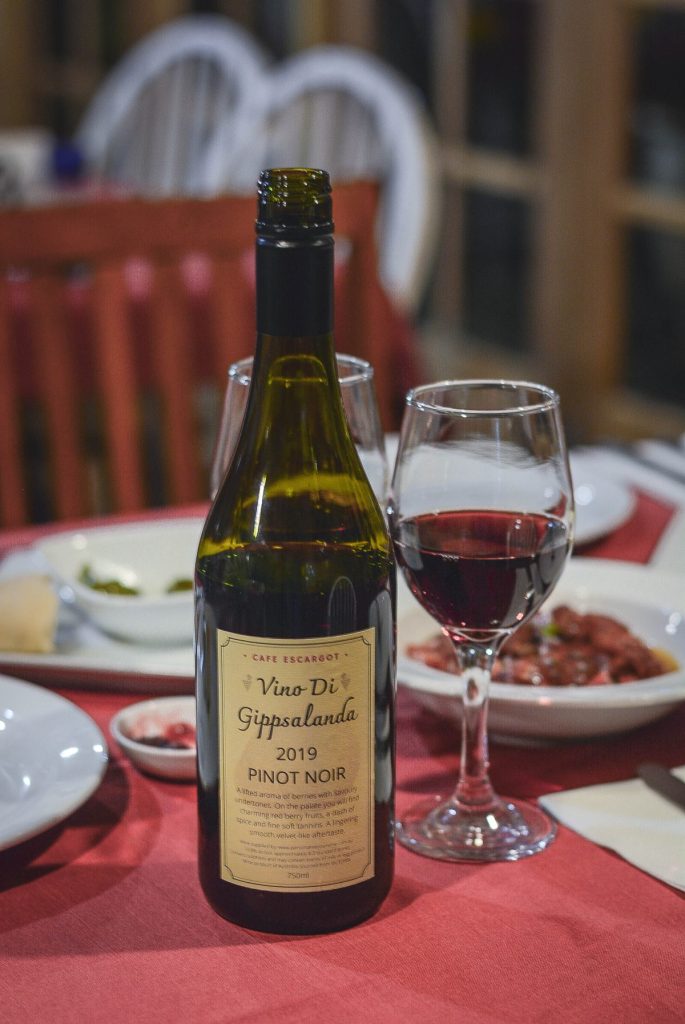 red wine in glass alongside bottle