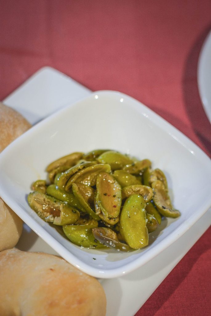 marinated green olives in white bowl