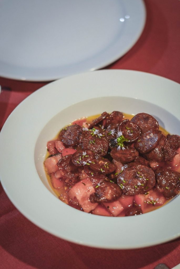 chorizo in tomato salad served in white plate