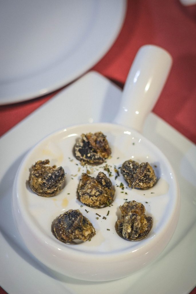 escargots with herbs in white bowl
