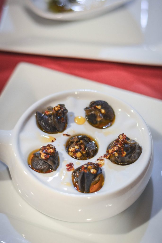 escargots with chilli oil in white bowl