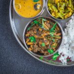 close up of Indian squid curry in steel bowl