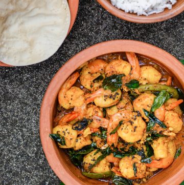 prawns in earthenware pot with rice and pappadums on the side