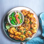 Fried prawns on a plate with a salad on the side.