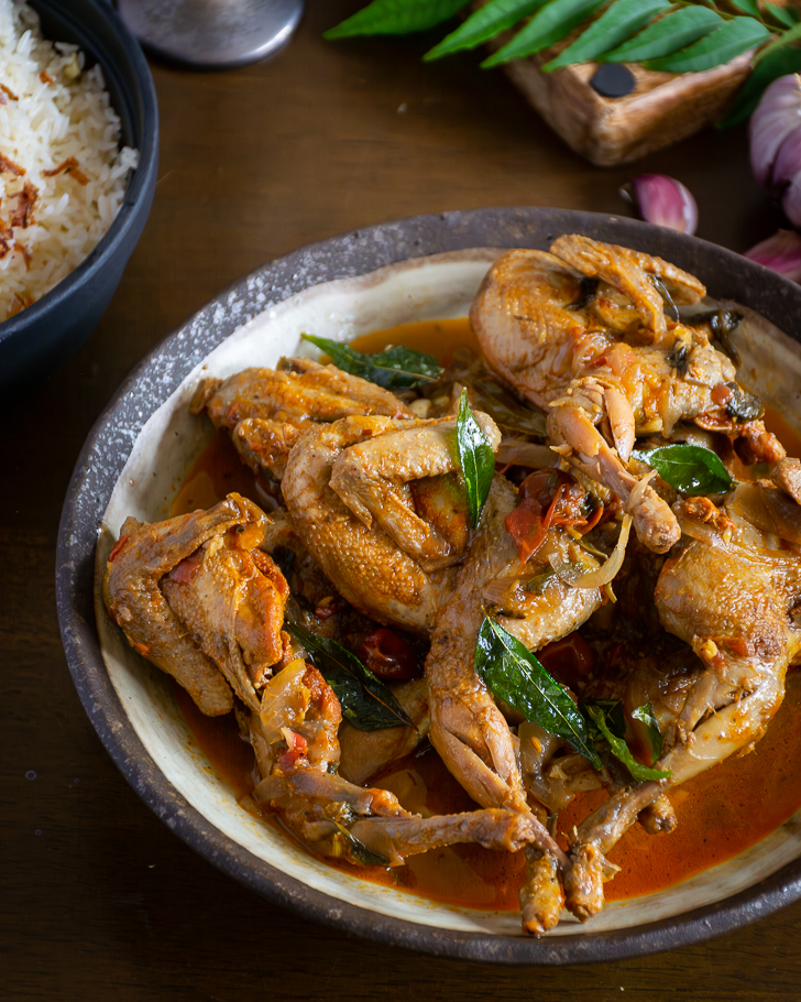 close up of quail curry served in grey bowl